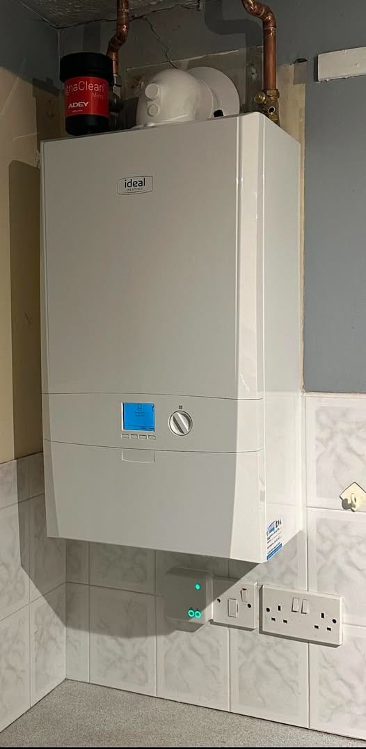 A new Ideal Logic+ Heat boiler on a kitchen wall with a red MagnaClean filter and copper pipework above it
